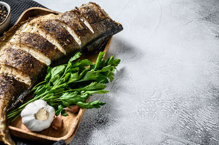 Cooking grilled haddock fish. Gray background. Top view. Copy space.