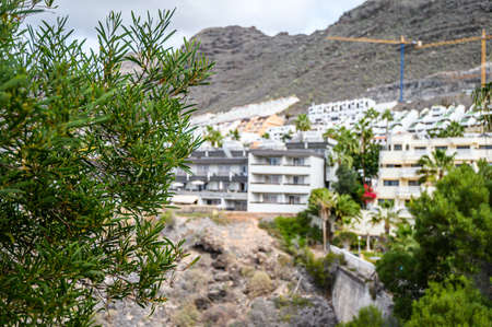 Panorama of hotels on the black volcanic mountains. Selective focus. 20.01.2020 Los Gigantes, Tenerife.のeditorial素材