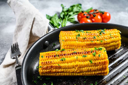 Grilled sweet corn with paprika, salt and cilantro. Gray background. Top view.