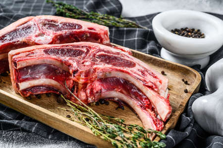 Raw fresh lamb meat on bones with rosemary and spices. Gray background. Top view.の写真素材