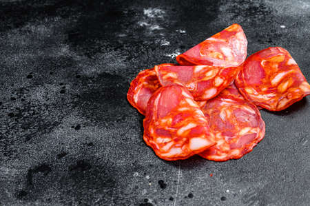 Sliced chorizo salami. Spanish traditional chorizo sausage. Black background. Top view. Space for textの写真素材