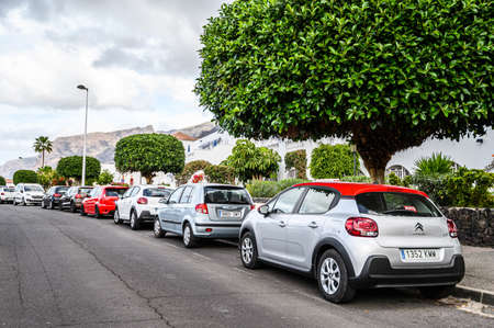 A road with parked cars along the houses. Selective focus. 20.01.2020 Los Gigantes, Tenerife.