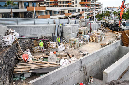 Laborers working on modern constraction site. Fast urban development consept. 20.01.2020 Los Gigantes, Tenerife.のeditorial素材