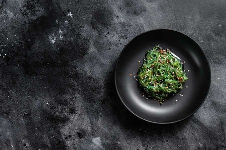 The seaweed salad with sesame seeds. Black background. Top view. Copy space.の写真素材