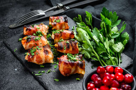 Baked bacon wrapped chicken breast. Black background. Top view.の写真素材
