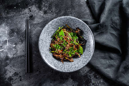 Soba noodles with beef, carrots, onions and sweet peppers. Stir fry wok. Black background. Top view.の写真素材