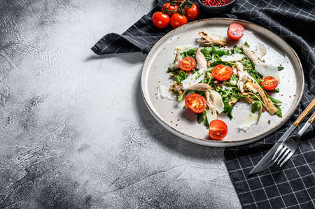 Salad with chicken, arugula, walnuts, tomatoes and Parmesan. gray background. Top view. Copy space.の写真素材