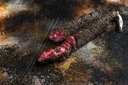 Fuet, Salami. Traditional Spanish sausage. Black background. Top view.