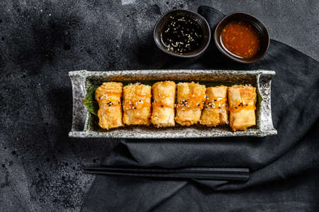 Fried spring rolls. Black background. Traditional Chinese cuisine. Top view.