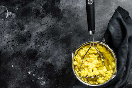 Cooking mashed potatoes in a pot. black background. top view. Copy space.の写真素材