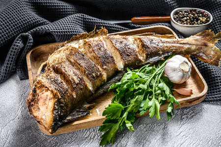 Cooking grilled haddock fish. Gray background. Top view.