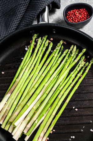 Fresh green organic asparagus in a pan. Black background. Top view.の写真素材
