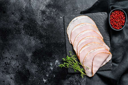 Cooked pastrami pork, gourmet ham. Black background. Top view. Copy space.の写真素材