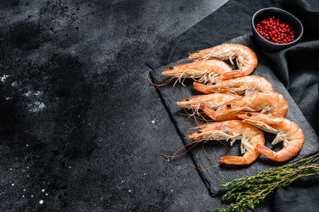 Raw fresh Prawns, shrimps Langostino on a stone Board. Black background. Top view. Copy space.の写真素材