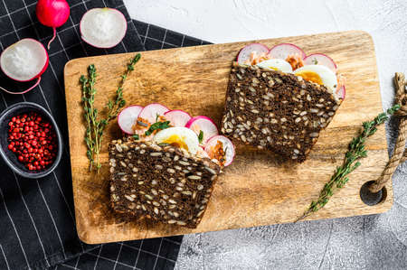 Grain bread sandwiches with hot smoked salmon, eggs and radishes. Healthy balanced food. Gray background, top viewの写真素材