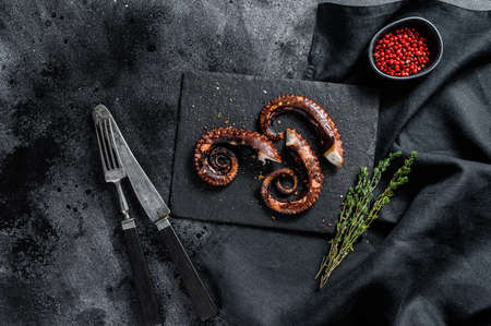 Grilled octopus tentacles. Fresh seafood. Black background. Top view.