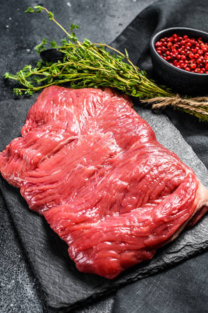 Raw flank steak, marbled meat. Black background. Top view. Copy space.の写真素材