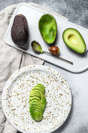 Sliced ripe avocado. Gray background. Top view.