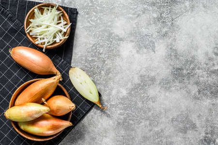 Yellow raw shallot onions, sliced and halved. Gray background. Top view. Space for text.の写真素材