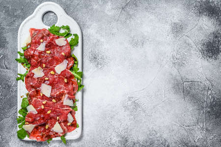 Carpaccio made of raw marbled beef. Gray background. Top view. Space for text.の写真素材