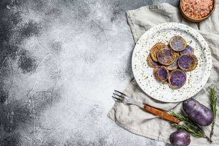 Fried purple potatoes with pink salt. Gray background. Top view. Space for text.の写真素材