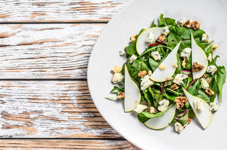 Diet salad with blue Gorgonzola cheese, pears, nuts, chard and arugula. White background. Top view. Copy space.の写真素材