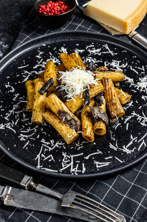 Pasta tortiglioni with black truffle and Boletus edulis, white mushroom. Black background. Top view.の写真素材