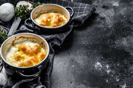 Julienne with chicken and mushroom in portion forms. Black background. Top view. Copy space.の写真素材