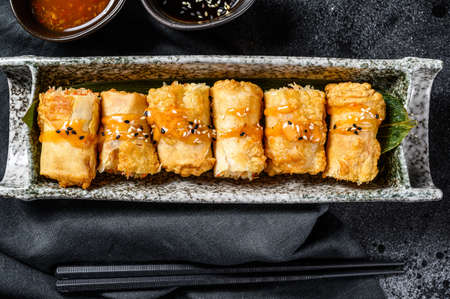 Traditional Chinese vegetable spring rolls. Vegetarian food. Black background. Top view.の写真素材