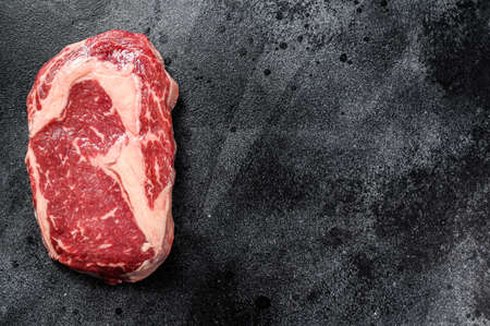 Raw Steak Ribeye. Black Angus Rib eye. black background. top view. Copy space.