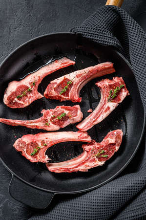Rack of lamb , raw meat with bone. Organic lamb meat. Black background. Top view.