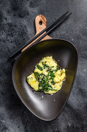 scrambled eggs with spinach and Parmesan cheese with sesame. Black background. Top view.の写真素材