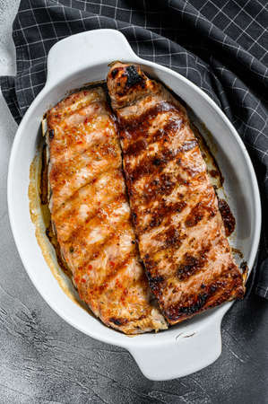 Spicy hot grilled pork spare ribs from BBQ served in a pan. Gray background. Top view.の写真素材