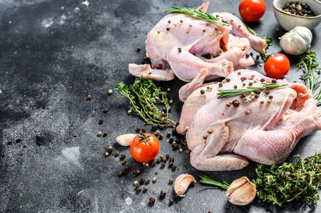 Organic farm raw whole chicken with herbs. Black background. Top view. Copy space.の写真素材