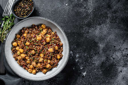 Boiled quinoa with chickpeas. Healthy food, diet. Black background. Top view. Copy space.