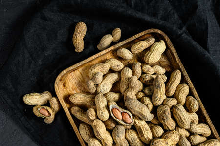 Peanuts in a shell. Organic raw groundnut. Black background. Top view.の写真素材