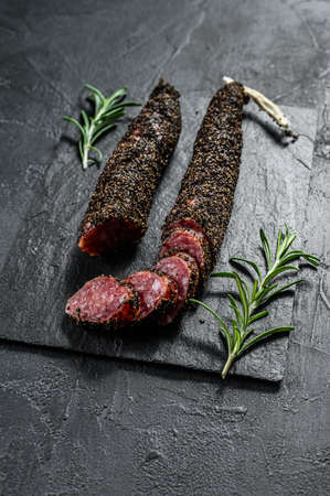 Sausage fuet. Pork sausage. Italian antipasto. Black background. Top view.