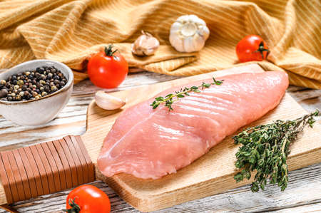 Raw Turkey steaks. Breast fillet with herbs. White wooden background. Top view.の写真素材