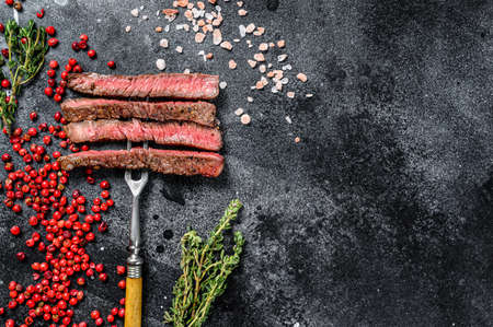Grilled sliced Denver steak. Barbecue beef. Black background. Top view. Copy space.の写真素材