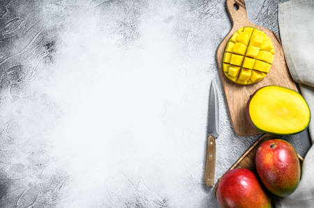 Ripe sliced mango fruit on a chopping Board. Gray background. Top view. Copy space.の写真素材