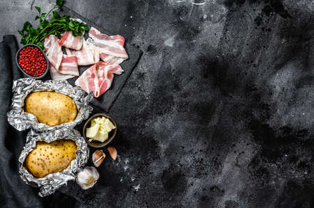 Recipe for cooking baked potatoes. Ingredients bacon, butter, parsley and cheese. Black background. Top view. Copy space.の写真素材