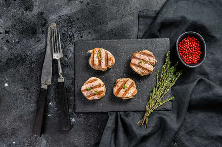 Tender boneless grilled pork chops. steak tenderloin. black background. Top view.の写真素材