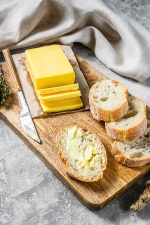 Farm butter and fresh baguette with butter. Gray background.Top view.の写真素材