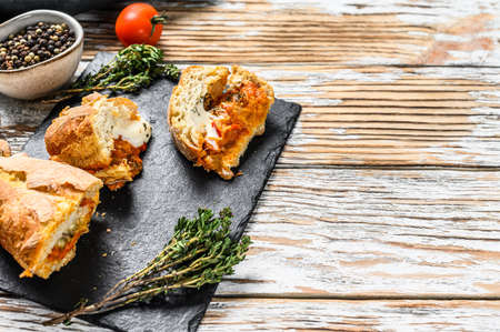 Baguette stuffed with eggplants, tomatoes and cheese. A delicious vegetarian lunch, tasty snacks, homemade sandwich. Gray background. Top view. Copy space.の写真素材