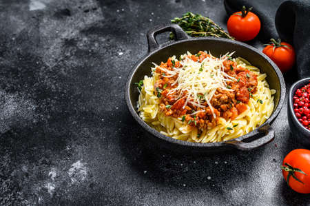Orzo pasta, risone with Bolognese sauce and ground beef. Black background. Top view. Copy space.の写真素材
