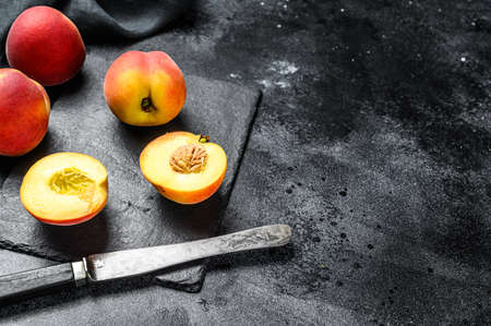 Organic Peaches fruit on a black stone Board. Black background. Top view. Copy space.の写真素材