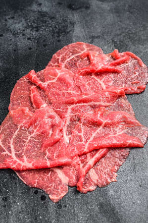 Slices of Beef Capriccio, raw meat. Black background. Top view.の写真素材
