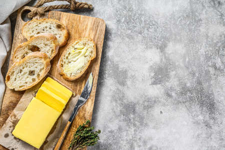 Farm butter and fresh baguette with butter. Gray background.Top view. Copy space.の写真素材