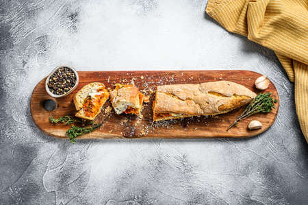 Vegetarian baguette submarine sandwich with grilled eggplant, pepper and feta cheese. Gray...