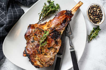 BBQ lamb leg with herbs. Gray background. Top view.